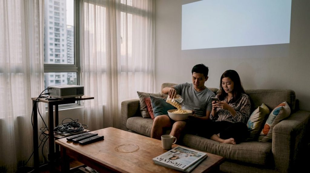 Couple watches projector in apartment living room
