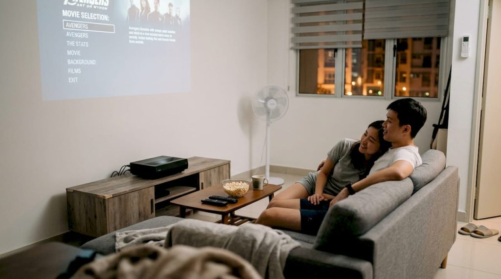 Couple using projector in small living room