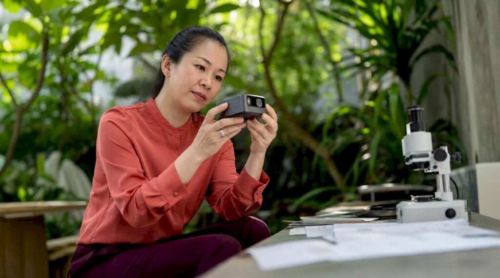 Engineer examining micro LED projector in lab