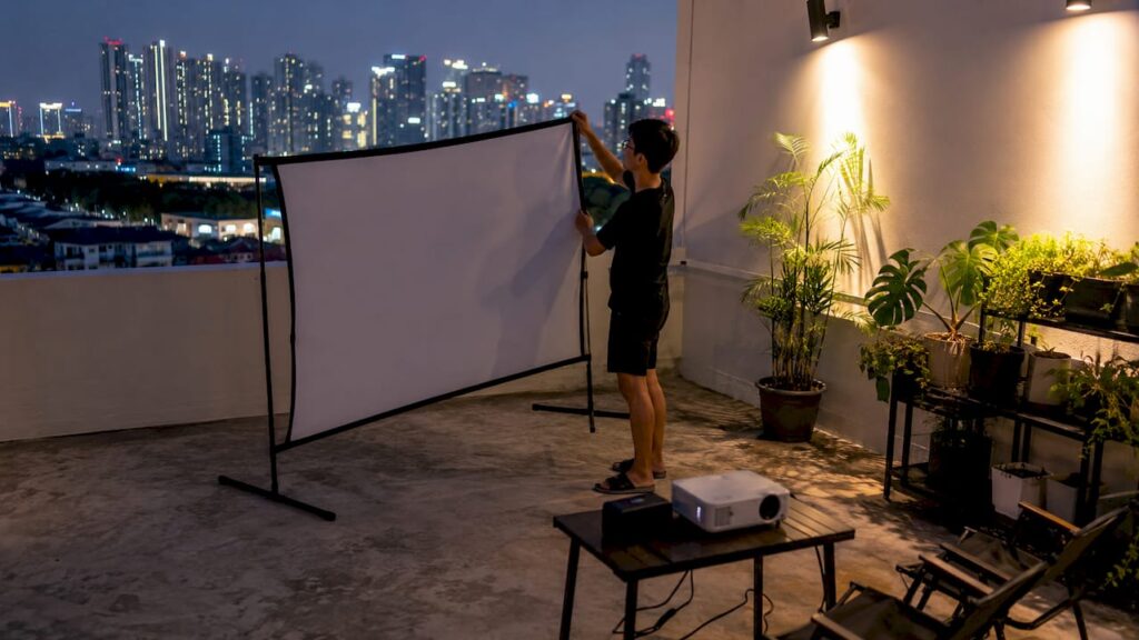 Man setting up portable projector screen outdoors