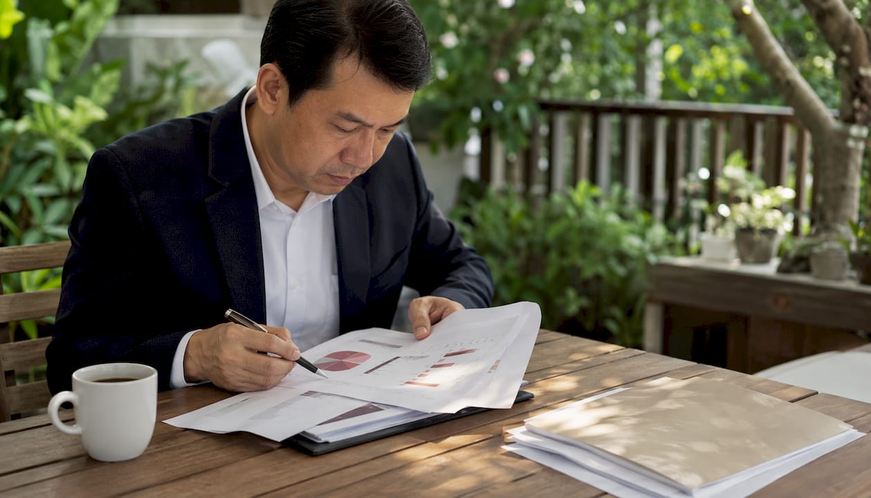 Seorang lelaki sedang meneliti susunan persembahan yang dicetak di atas kertas.